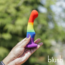 Charger l&#39;image dans la galerie, blush Avant Pride Freedom Plug being held from the side, showing the size scale of the product compared to a female hand. On the bottom right of the image is the blush logo.