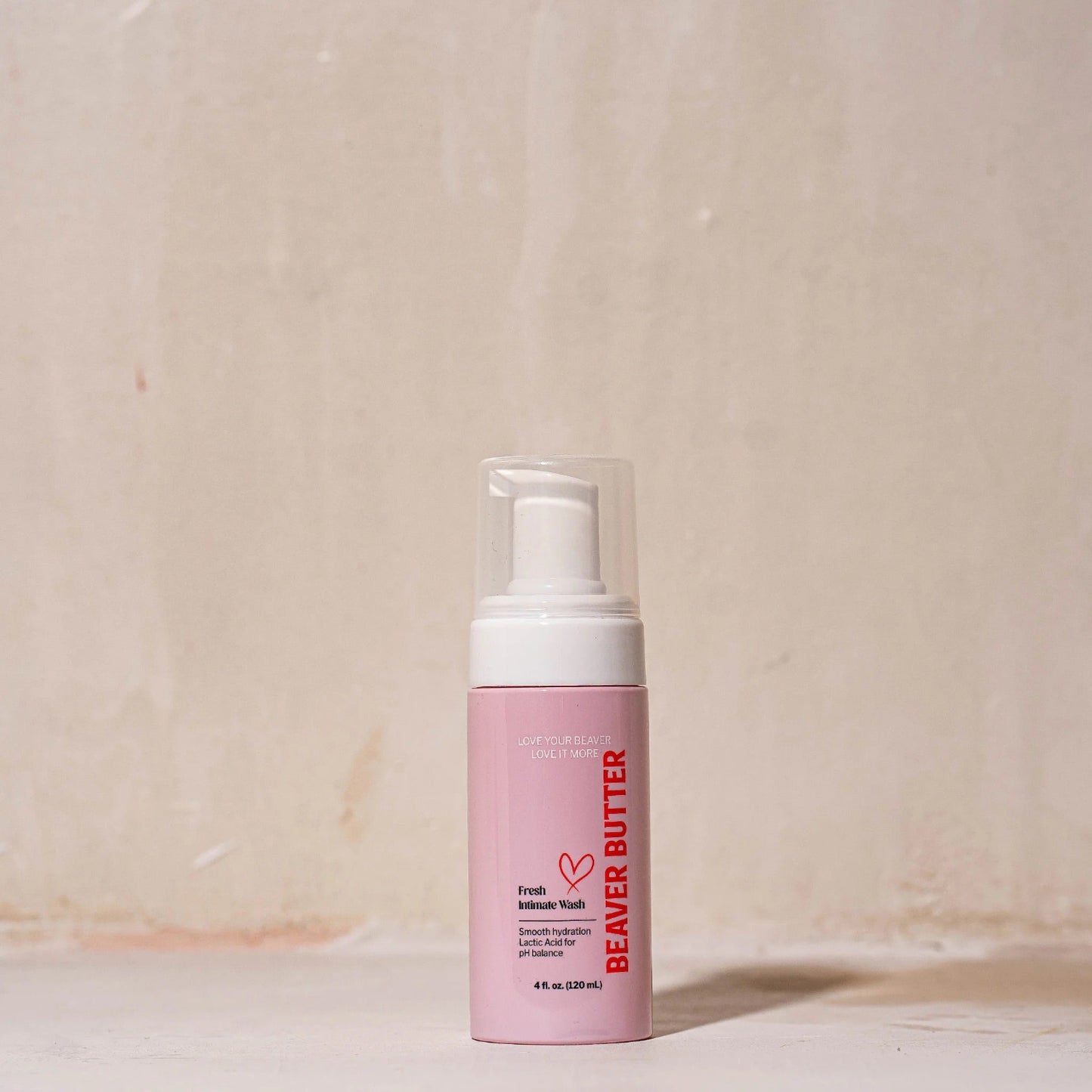 The 120 ml / 4 oz pink bottle of Beaver Butter Fresh Intimate Wash standing on a neutral, textured surface.