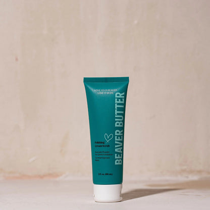 A 3 fl. oz. (88 mL) travel-sized teal tube of Beaver Butter Polishing Cream Scrub standing upright on a minimalist surface against a warm, neutral-toned background.