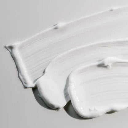 Three smooth, creamy swatches of Beaver Butter Soothing Shave Cream displayed on a neutral grey surface to highlight its rich consistency.