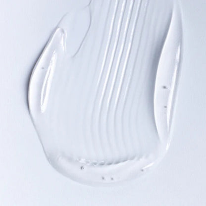 A close-up of a viscous, transparent personal lubricant gel on a white background showing smooth, hydrating ridges.