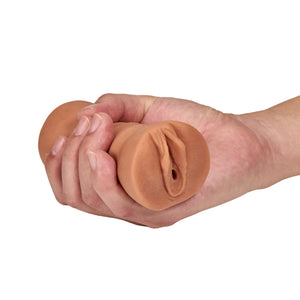 blush Julieta Vibrating Stroker being held in a clinched fist, showing the front of the product.