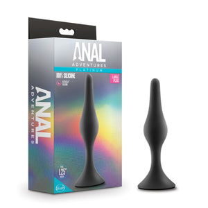 On the left side of the image is the product packaging. On the left side of packaging is the Anal Adventures logo. On the front of the packaging is the Anal Adventures Platinum logo, product name: 100% silicone Large Plug, product feature icons for: Ultrasilk silicone; Plug .75" width, in the middle is a side image of the product standing on its base, and the blush logo in the bottom left. Beside the packaging is the product standing on its base.