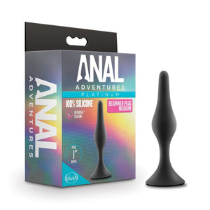 On the left side of the image is the product packaging. On the left side of packaging is the Anal Adventures logo. On the front of the packaging is the Anal Adventures Platinum logo, product name: 100% silicone Beginner Plug Medium, product feature icons for: Ultrasilk silicone; Plug .75" width, in the middle is a side image of the product standing on its base, and the blush logo in the bottom left. Beside the packaging is the product standing on its base.