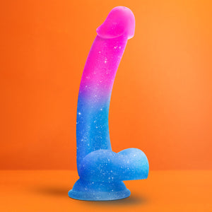 Bottom side view of the blush Avant Chasing Sunsets Puria Platinum-Cured Silicone Dildo, placed on its suction cup with an orange background.