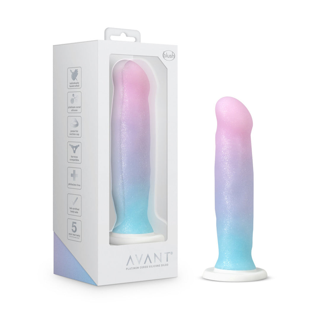On left side of image is product packaging. On left side of product packaging are product feature icons for: Individually handcrafted; Platinum cured silicone; Powerful suction cup; Harness compatible; Phthalate free; Lab certified body safe; 5 year warranty (US & Canada only). On front of package from top has blush logo, in middle a cutout display of product, and on bottom Avant Platinum cured Silicone Dildo. To right is product blush Avant Lucky Dildo, placed on its suction cup.