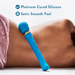 Feature icons for Platinum cured silicone; Satin smooth feel. Below is an image of a woman's back laying with the Blush Dianna Powerful Massage Wand leaning against her hip.