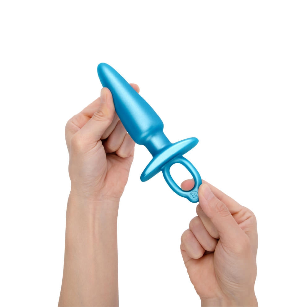 b-Vibe Butties Sleek Tapered Silicone Plug being held by two hands. The left hand is holding the tip of the plug, and the right hand is holding the ring handle.