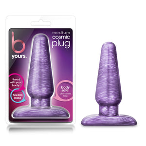 On the left side of the image is the product packaging. On the product packaging is the b Yours brand logo, product name medium cosmic plug, in the middle is a cutout display of the product inside, and text bubbles: "I bend with my booty" (pointing to lower part of product); "flexible base" (pointing to the bottom of product); "body safe: Phthalate free" (pointing to lower part of product. On the right side of image is the product blush B Yours Cosmic Plug, placed on its base.