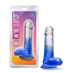 On the left side of the image is the product packaging. On the product packaging (from the top): b yours by blush Stella blue, text bubbles "6 Inch dildo"; "Love my Realistic feel"; "Try my suction cup. It's harness Compatible!"; "I'm body safe: Phthalate free", and in the middle is an image of the product. On the right side of the image is the product blush B Yours Stella Blue 6 Inch Dildo, placed on its suction cup.