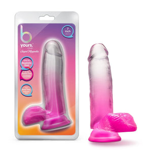 On the left side of the image is the product packaging. On the packaging (from the top) b yours logo, by blush Sugar Magnolia, text bubbles: "7 inch dildo"; "Love my realistic feel"; Try my suction cup. It's harness compatible!"; "I'm body safe: Phthalate free"(pointing to product), and in the middle is a cutout display of the product inside. Beside the packaging is the product blush B Yours Sugar Magnolia 7 Inch Dildo, placed on its suction cup.
