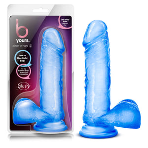On the left side of the image is the product packaging. On the product packaging are the b yours logo, sweet n' hard 2 (product name), text bubbles pointing to the image of the product: "I'm body safe: Phthalate free"; "love my realistic feel"; "Try my suction cup. It's harness compatible!", and the blush logo below. Beside the packaging is the product blush B Yours Sweet N' Hard 2 Realistic Dildo, placed on its suction cup.