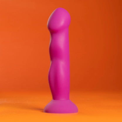 Profile studio shot of the purple Avant Suko silicone dildo standing on a vibrant orange background.