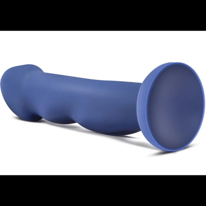 Side profile view of the blue Avant Suko Indigo D12 dildo lying flat, showing the flared suction cup base and curved ergonomic shaft.