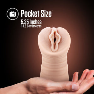 An image of the blush EnLust Destini Vibrating Stroker standing on the palm of a hand. On the top of the image is a feature icon for Pocket Size: 5.25 inches; 13.3 centimetres.