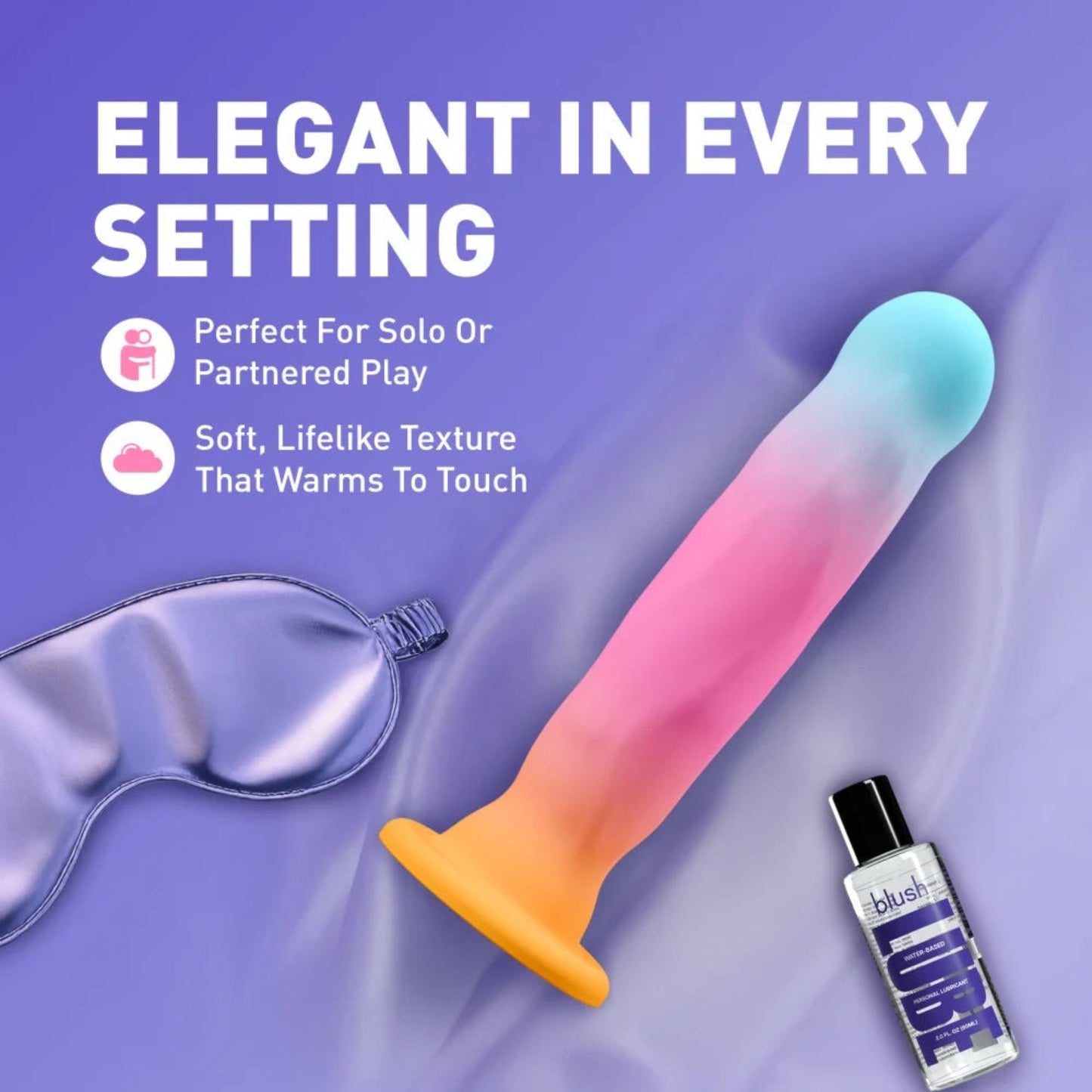 Avant Golden Dawn multicolour dildo arranged beside a silk sleep mask and water-based lubricant on satin bedding.