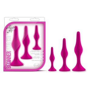 On the left side of the image is the Product packaging. On the packaging is the Luxe logo, below is the product name: Beginner Plug Kit, in the middle are the products inside completely visible through clear packaging, product feature icons for: 3 sensual sizes; Platinum cured silicone; Body safe phthalate free; Satin smooth, and in the bottom right corner is the blush logo. Beside the packaging are the 3 plugs, standing beside each other from small to large.
