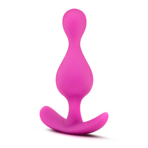 Top side view of the blush Luxe Explore Silicone pink Anal Plug, standing on its ez-handle.