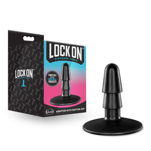 Image showing the packaging standing beside the Lock On adapter. On the left side of the packaging is the Lock On logo, on the front of the packafinf is the Lock On logo, slogan: pleasure tools, an illustrated stamp "compatible with all Lock On products", an image of the product, the blush logo at the bottom, and product name: Adapter With Suction Cup.