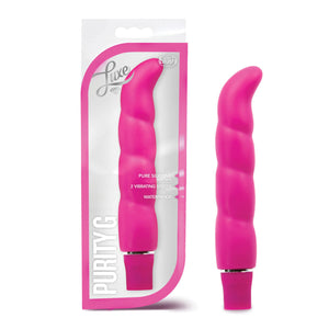 On the left side of the image is the pink variant product packaging. On the packaging is the Luxe & blush logos, product feature icons for: Pure silicone; 2 vibrating speeds; waterproof, on the bottom left is the product name: Purity G, and the product fully visible inside the packaging. Beside the packaging is the product, blush Logo Purity G pink Vibrator.