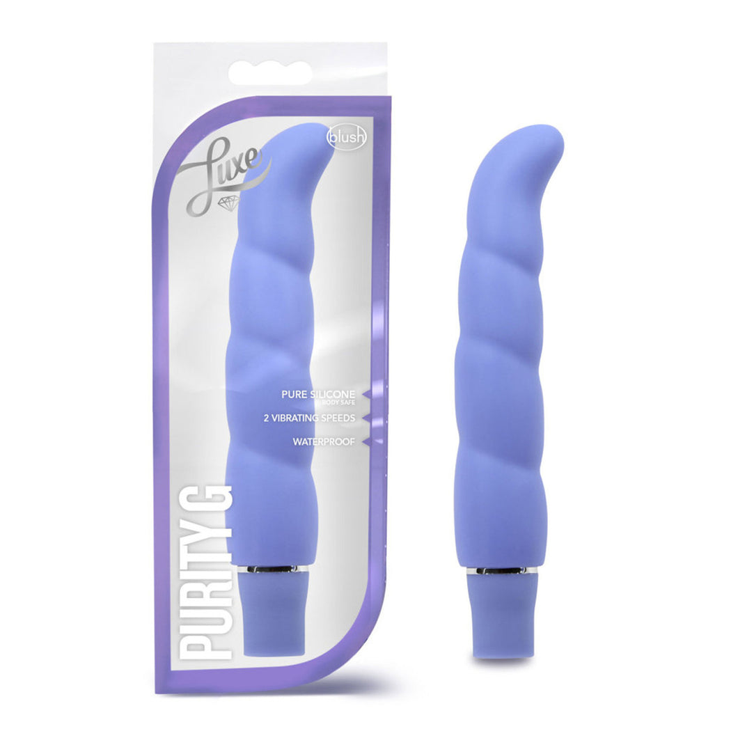 On the left side of the image is the periwinkle variant product packaging. On the packaging is the Luxe & blush logos, product feature icons for: Pure silicone; 2 vibrating speeds; waterproof, on the bottom left is the product name: Purity G, and the product fully visible inside the packaging. Beside the packaging is the product, blush Logo Purity G periwinkle Vibrator.