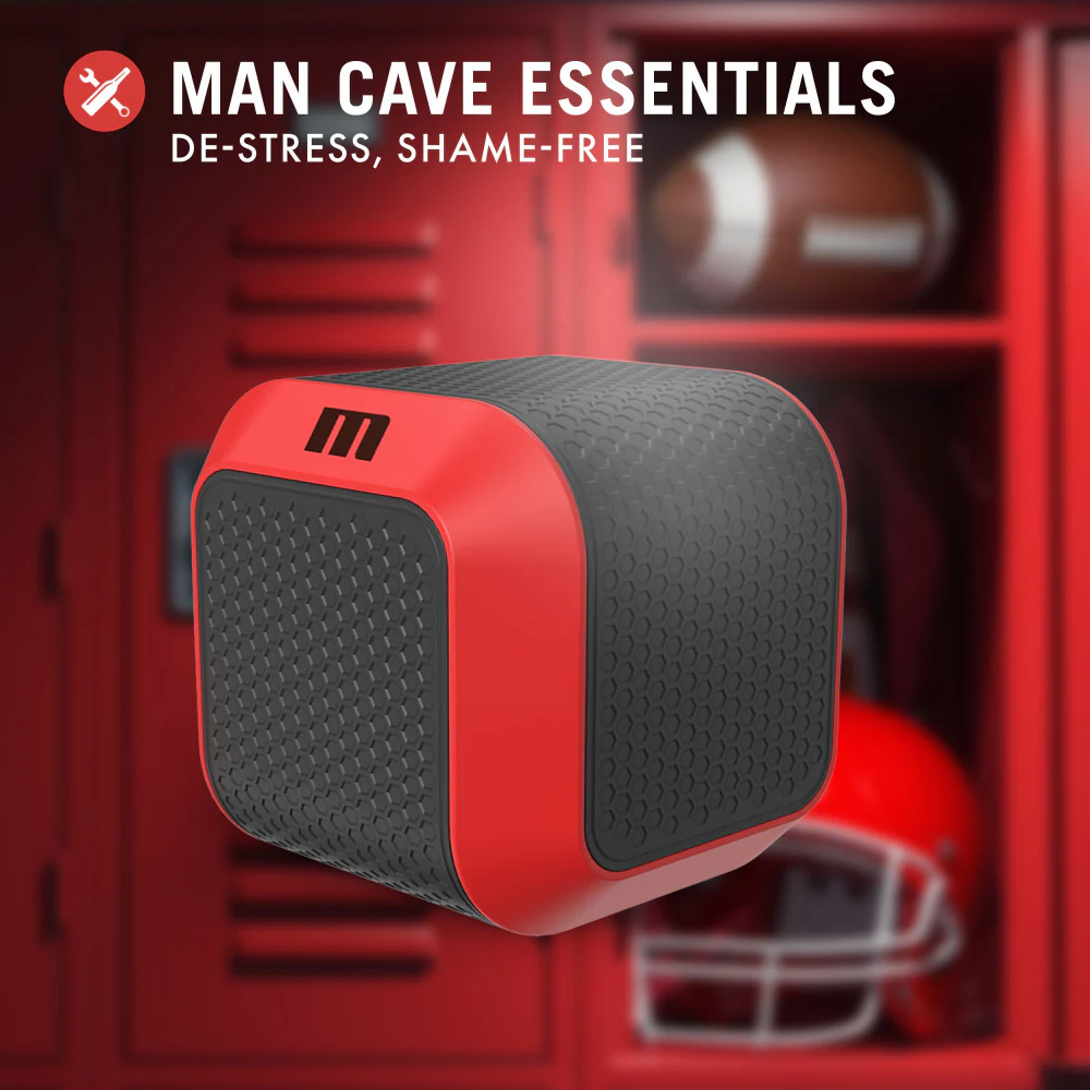 Front side image of the blush M For Men Slambox Thrusting & Rotating Stroker, with a background image of a locker room. On the top is a feature icon for man cave essentials: Destress, Shame-Free.