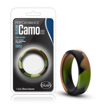 Load image into Gallery viewer, On the left side of the image is the product packaging. On the packaging is the performance logo, product name: Silicone Camo Cock rings, product features: Pure silicone; Flat design for a comfortable &amp; secure fit; strong &amp; stretchy, in the middle is the product visible through clear packaging, &quot;1.5inch (38mm) diameter, and the blush logo at the bottom. Beside the packaging is the product blush Performance Silicone Camo Cock Rings.
