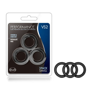 On the left side of the image is the product packaging. On the packaging is the Performance logo, product name: VS2 Pure Premium Silicone Cock Rings, product features: Strong & stretchy; phthalate free, in the middle is the product inside visible through clear packaging, at the bottom is the blush logo, and "3 Pack small" written in the bottom right corner. Beside the packaging is the product, standing from its side.