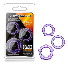 Load image into Gallery viewer, On the left side of the image is the product packaging. On the packaging are the Stay Hard &amp; blush logos, product features: For Super hard erections; Body - phthalate free; May aid in delaying ejaculation, in the middle are the products visible through clear packaging, &quot;Detailed instructions inside!&quot;, product name: Beaded Cock Rings, and slogan underneath: Perform like a stud. On the right side of the image are the Cock Rings layed out from Small to Large in a triangular formation.