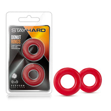 Charger l&#39;image dans la galerie, On the left side of the image is the packaging. On the packaging is the Stay Hard logo, product name: Donut Rings. product features: Super stretchy; Body safe; phthalate free; Laboratory certified - Body safe, on the right is the product inside visible through clear packaging, blush logo on the bottom left corner, and below is the slogan: perform like a stud. Beside the packaging is the product standing on its side the left cock ring is slightly in front of the right.