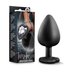 Load image into Gallery viewer, On the left side of the image is the product packaging. On the packaging is a background image of a female&#39;s backside wearing lingerie, and a photo of the product with the base facing up, product features: embedded with a beautiful gem; Perfect for more advanced players; Tapered tip for easy entry; Made of pure silicone; Satin smooth; 3.75&quot; length, Temptasia logo, and product name: Bling Plug - Large. Beside packaging is the product standing on its base.