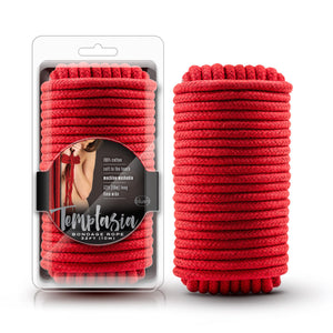 On the left side of the image is the red bondage rope packaging. Visible through the clear packaing is the black variant of the product inside, and wrapped around the packaging is the paackaging label. On the Packaging label is an image of a feamle bound with the red variant of the product, product features: 100% cotton; Soft to the touch; Machine washable; 32ft (10m) long 8mm wide, Temnptasia & blush logos below, Prouct name: Bondage rope 32ft (10m). Beside the packaging is the red variant of the product.
