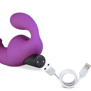 Close up on the blush Temptasia Cyrus Strapless Dildo's bullet vibe, with the charging cable, showing where to charge the bullet vibe.