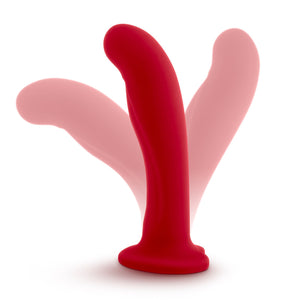 Side view of the blush Temptasia Jezebel Dildo standing on its suction cup base, with the tip of the shaft lookks bent in seperate ways, demonstrating the flexibility of the product.
