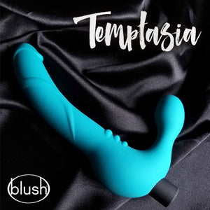 The blush Temptasia Luna Strapless Dildo laying on a black fabric, with Temptasia, and blush logos displayed.