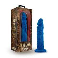 Load image into Gallery viewer, On the left side of the image is the product packaging. On the packaging is The Realm logo, and below is the product name: Draken. On the front of the package is the dildo inside visible through clear packaging, The Realm logo, and product name: Draken at the bottom. Beside the packaging is the product, standing on its suction cup.