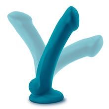 Load image into Gallery viewer, blush Temptasia Reina Dildo standing on its suction cup base, with the shaft bent in seperate directions, showing the flexibility of the dildo.
