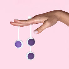 Charger l&#39;image dans la galerie, A females is holding the single with a 36.9 gram / 1.3 oz snapped in, and a double with two 51 gram / 1.8 ounce kegel balls snapped in, with her fingers, and palm facing down.