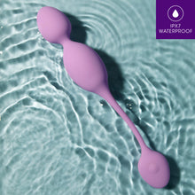 Load image into Gallery viewer, blush Wellness Raine Vibrating Kegel Ball laying in water with the wireless remote control. In the top right is a feature icon for IPX7 Waterproof.