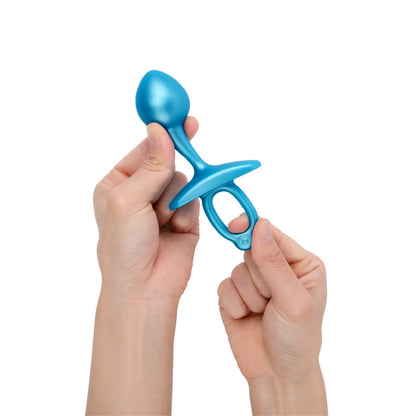 b-Vibe Butties Bulb Silicone Prostate Plug being held by two hands, one hand is showing the flexibility of the head, and the right hand is on the ring handle showing its stretchiness.