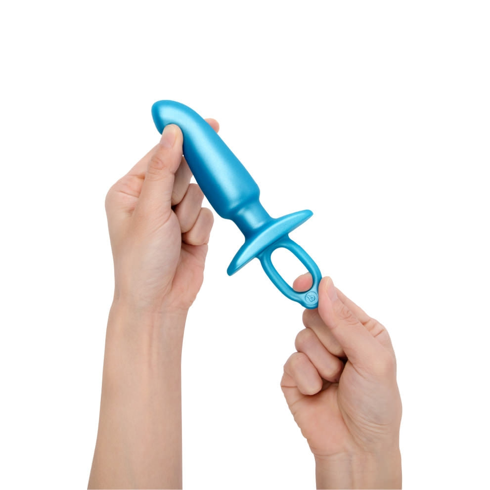 b-Vibe Butties Hither Silicone Prostate Plug being held at the tip with the left hand, and the right hand is stretching the ring.