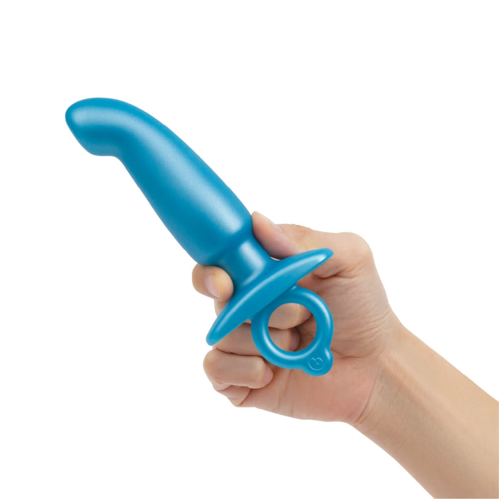 b-Vibe Butties Hither Silicone Prostate Plug being held with two fingers showing the size scale of the plug.