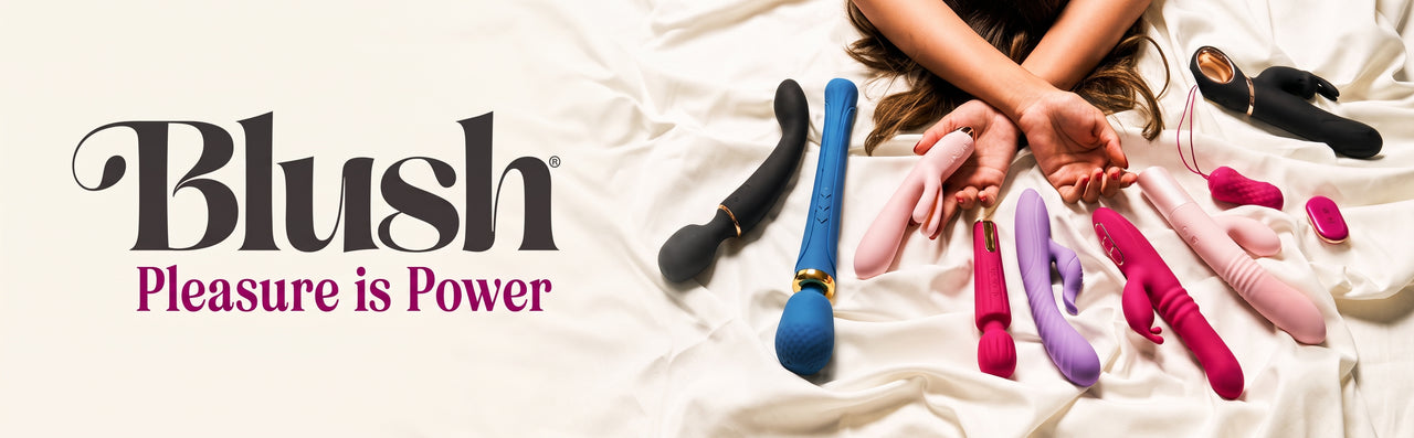 A promotional banner for Blush showing multiple personal massagers in pink, purple, blue, and black arranged on white satin bedding, with a person's hands and arms visible holding some of the devices. The Blush logo and the slogan 'Pleasure is Power' appear on the left.