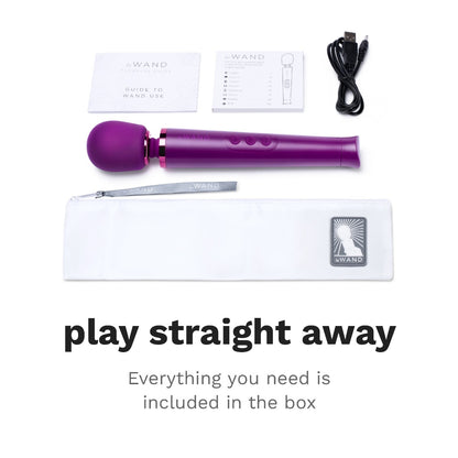 Caption shows: Play straight away everything you need is included in the box. Above is an image of all the included components: le Want Guide to Wand Use, an owner manual, USB charging cable, Le Wand Petite Dark Cherry Massager, and Le Wand storage bag.