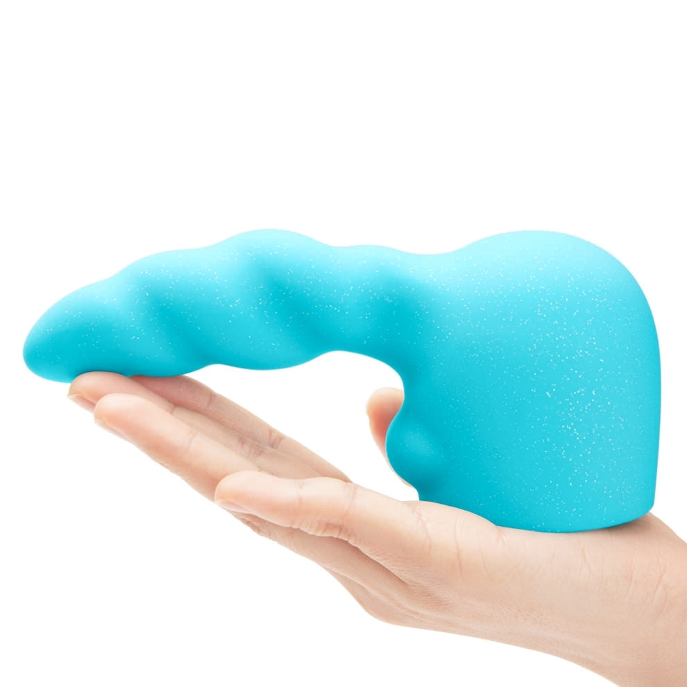 Le Wand Silicone Attachment standing on the palm of a hand showing the size scale of the product