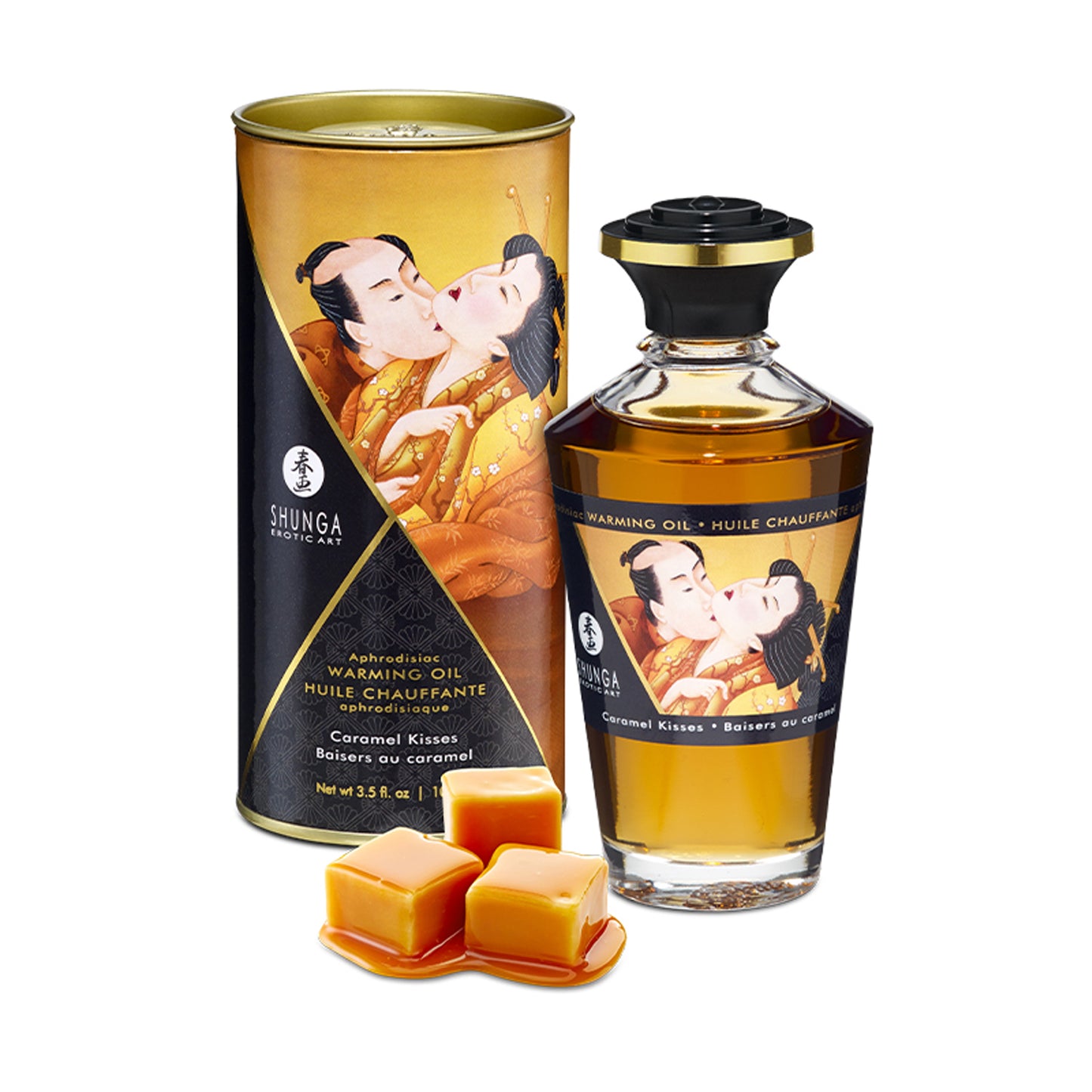 Shunga Caramel Kisses Warming Oil bottle and gold-toned canister, shown with caramel cubes to represent the sweet scent profile.