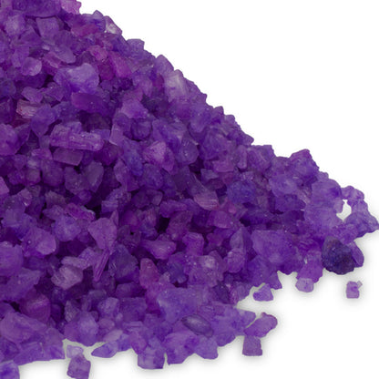 A close-up pile of vibrant purple "Exotic Fruits" scented Dead Sea salt crystals on a white background.