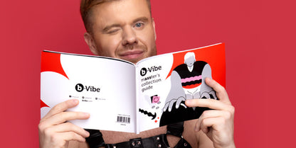 An image of a man winking while holding the b-vibe masster's collection guide open.