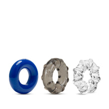 Load image into Gallery viewer, blush Stay Hard Triple Stretch 3 Pack Cock Rings side view side by side. Left to right: blue cock ring, dar grey cock ring, and clear cock ring.