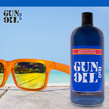 Load image into Gallery viewer, Gun Oil H2O logo on the top left of the image. with sky blue background, yellow/orange pair of sunglasses laying on tiles, and a Bottle of water-based lubricant Gun Oil H2O 32 oz / 960 mL